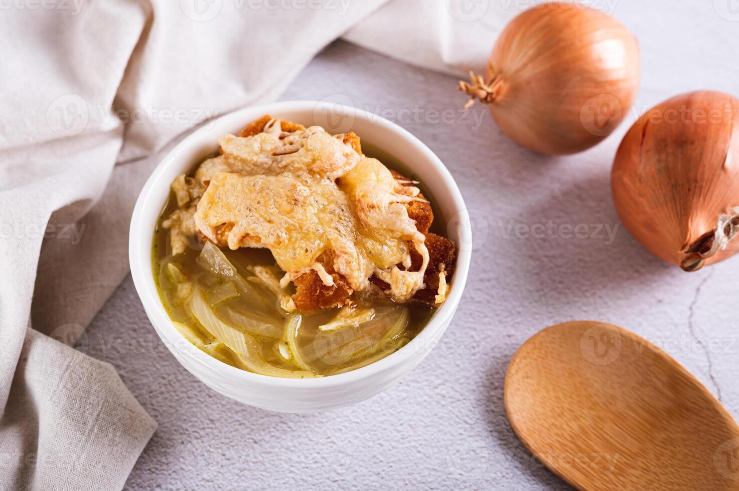 francés cebolla sopa con horneado queso un pan en un cuenco en el mesa foto