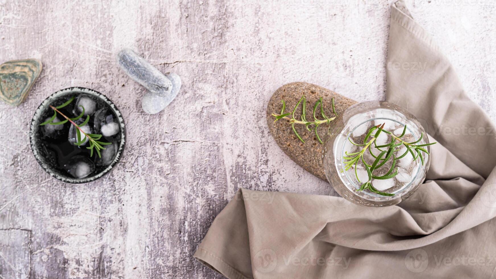 Glass with carbonated alcoholic drink with rosemary and ice in glass on table top view web banner photo