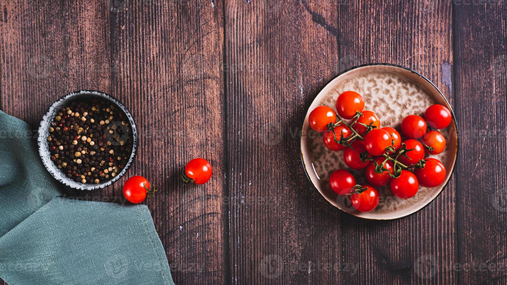 Plate with fresh cherry tomatoes on a wooden table top view web banner photo