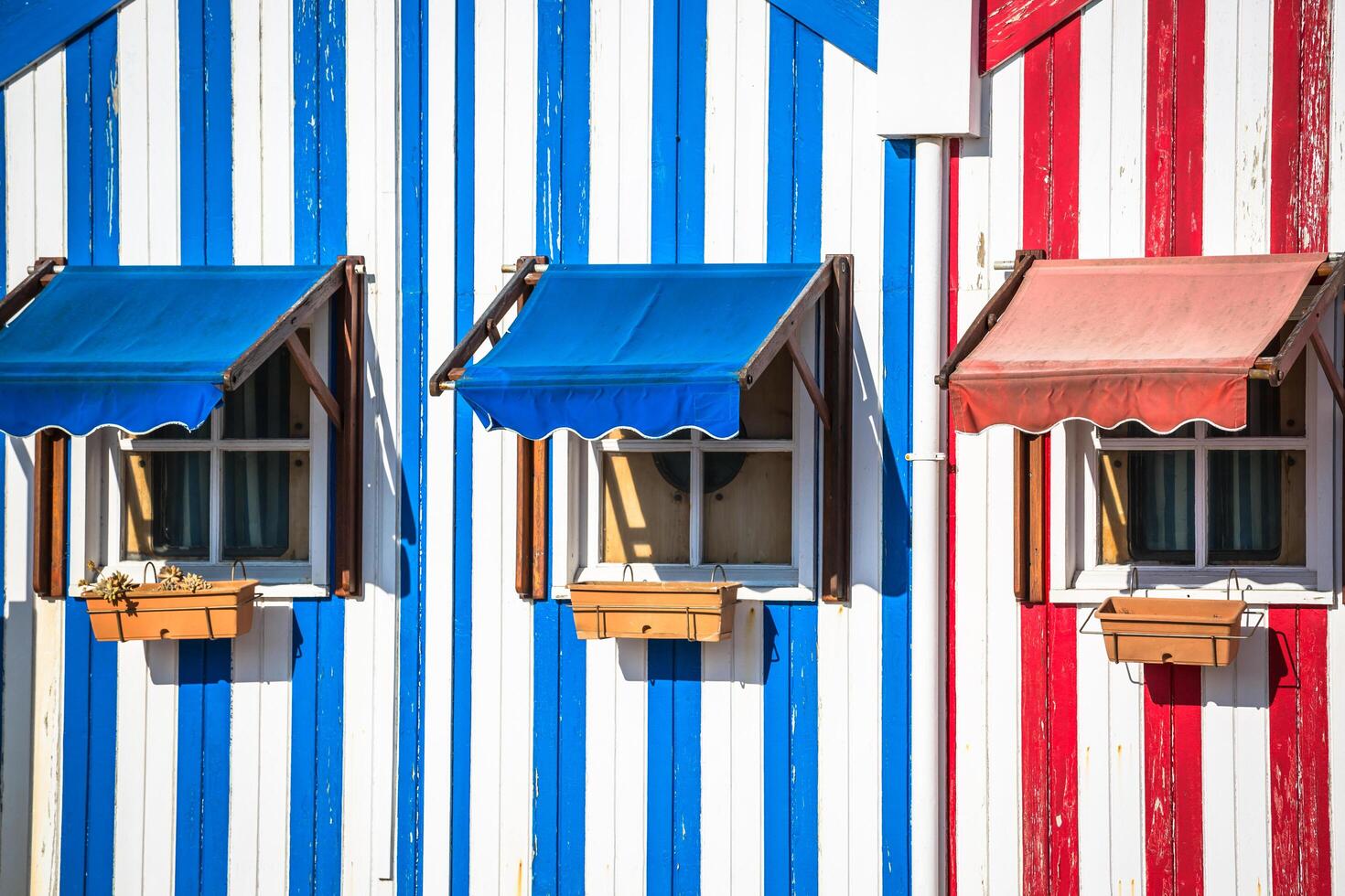 Colorful striped fishermen's houses in blue and red, Costa Nova, Aveiro, Portugal photo