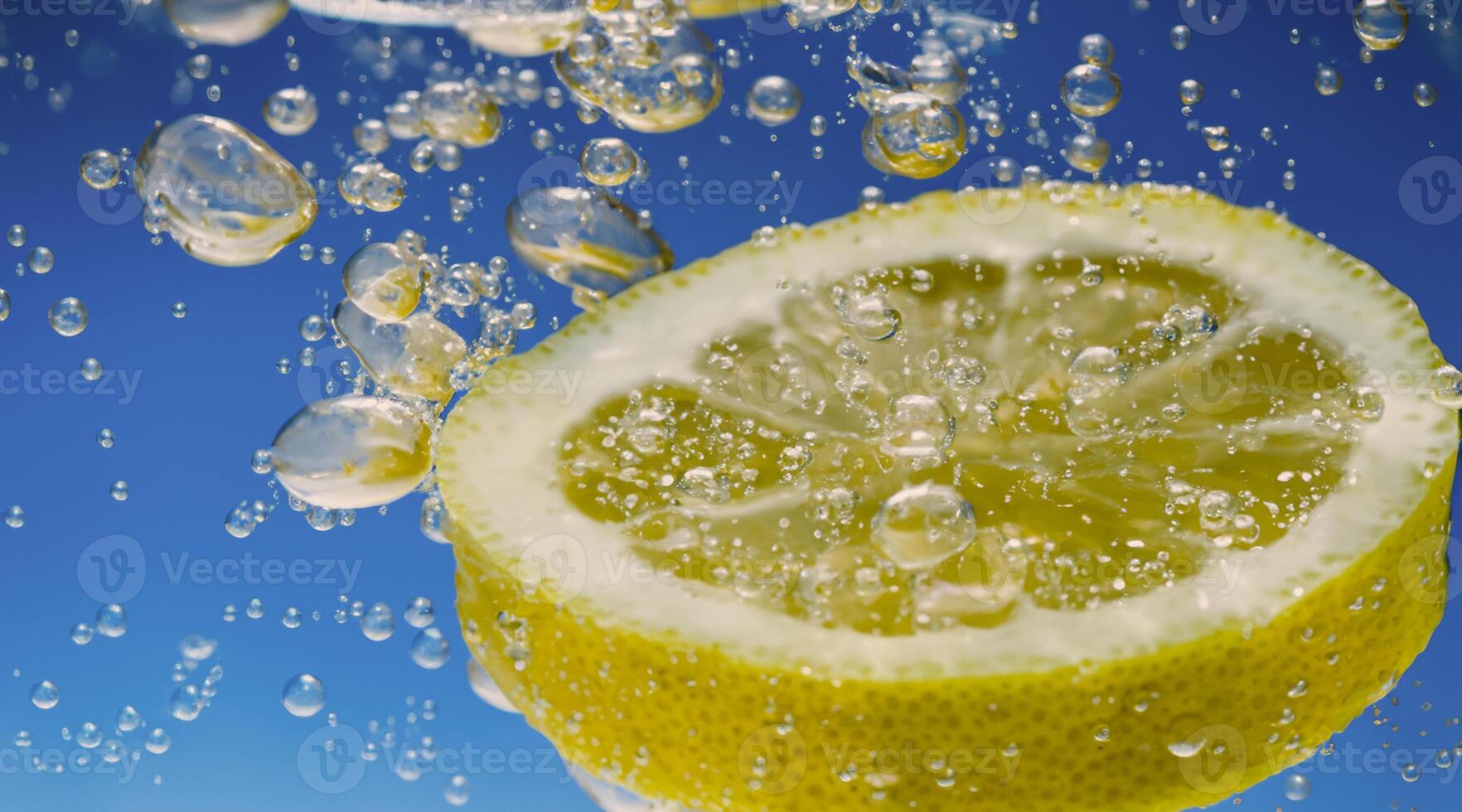 Underwater lemon slice in soda water or lemonade with bubbles. photo