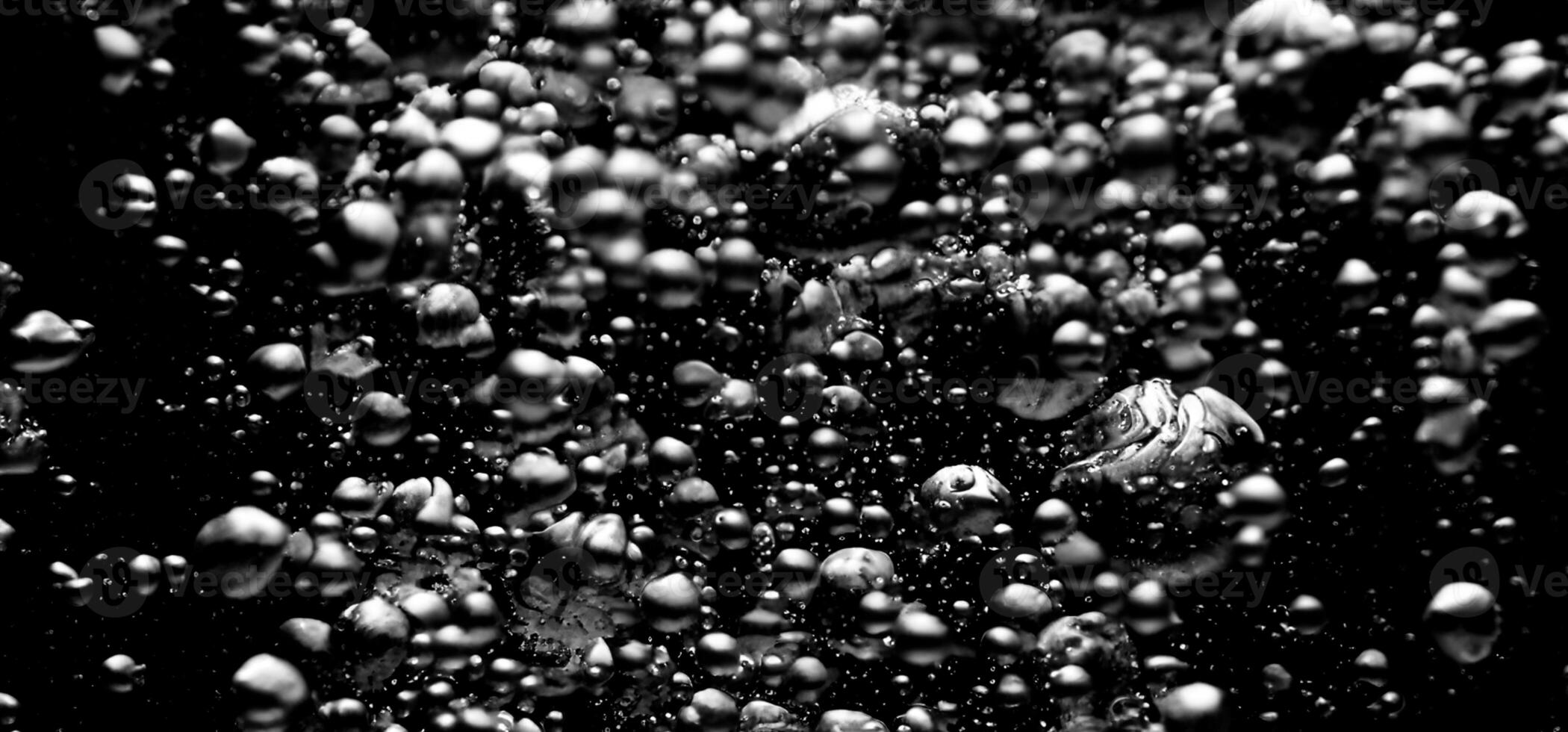 Soda water bubbles splashing underwater against black background. photo