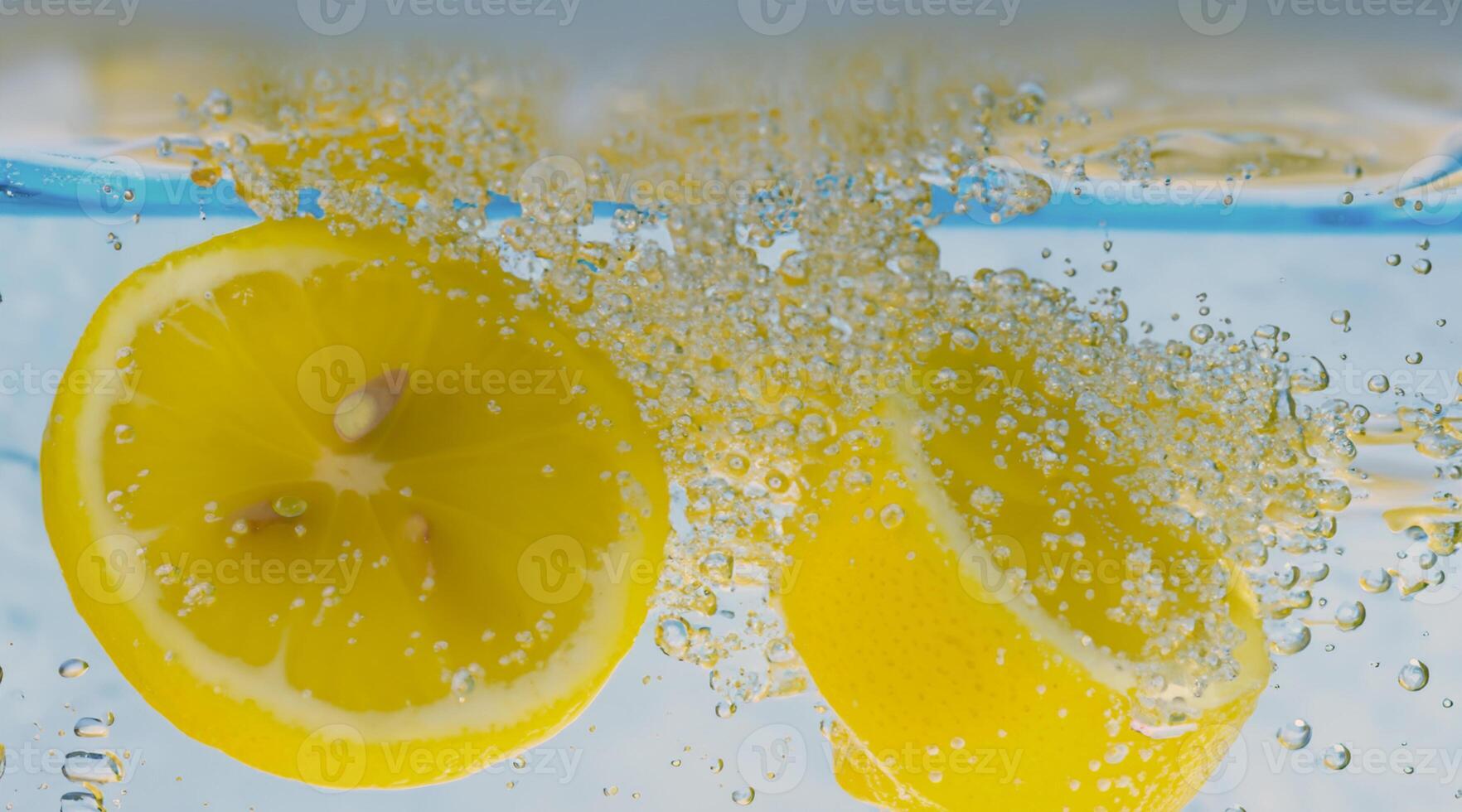 Underwater lemon slice in soda water or lemonade with bubbles. photo