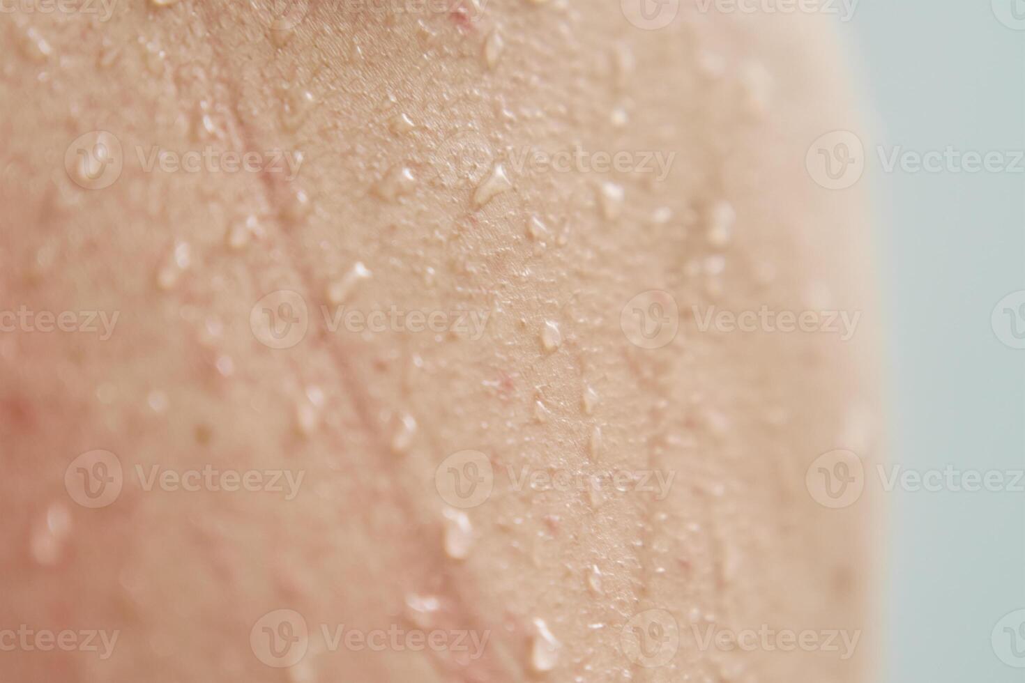 Female body skin with water drops in shower photo