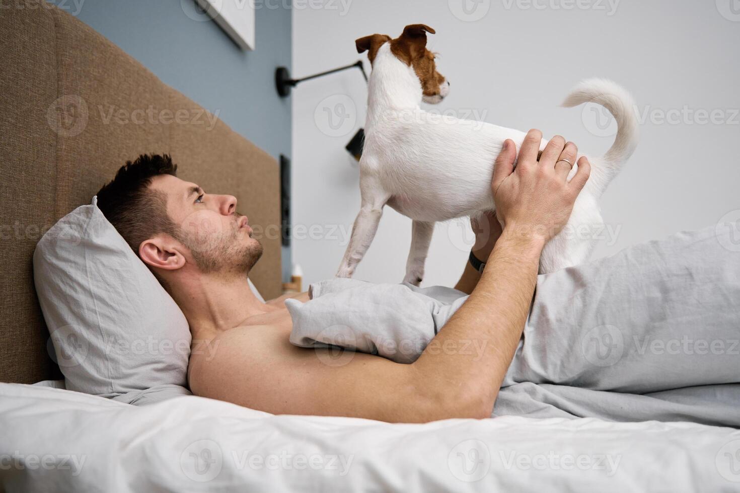hombre dormido en cama con perro. mascota afecto foto