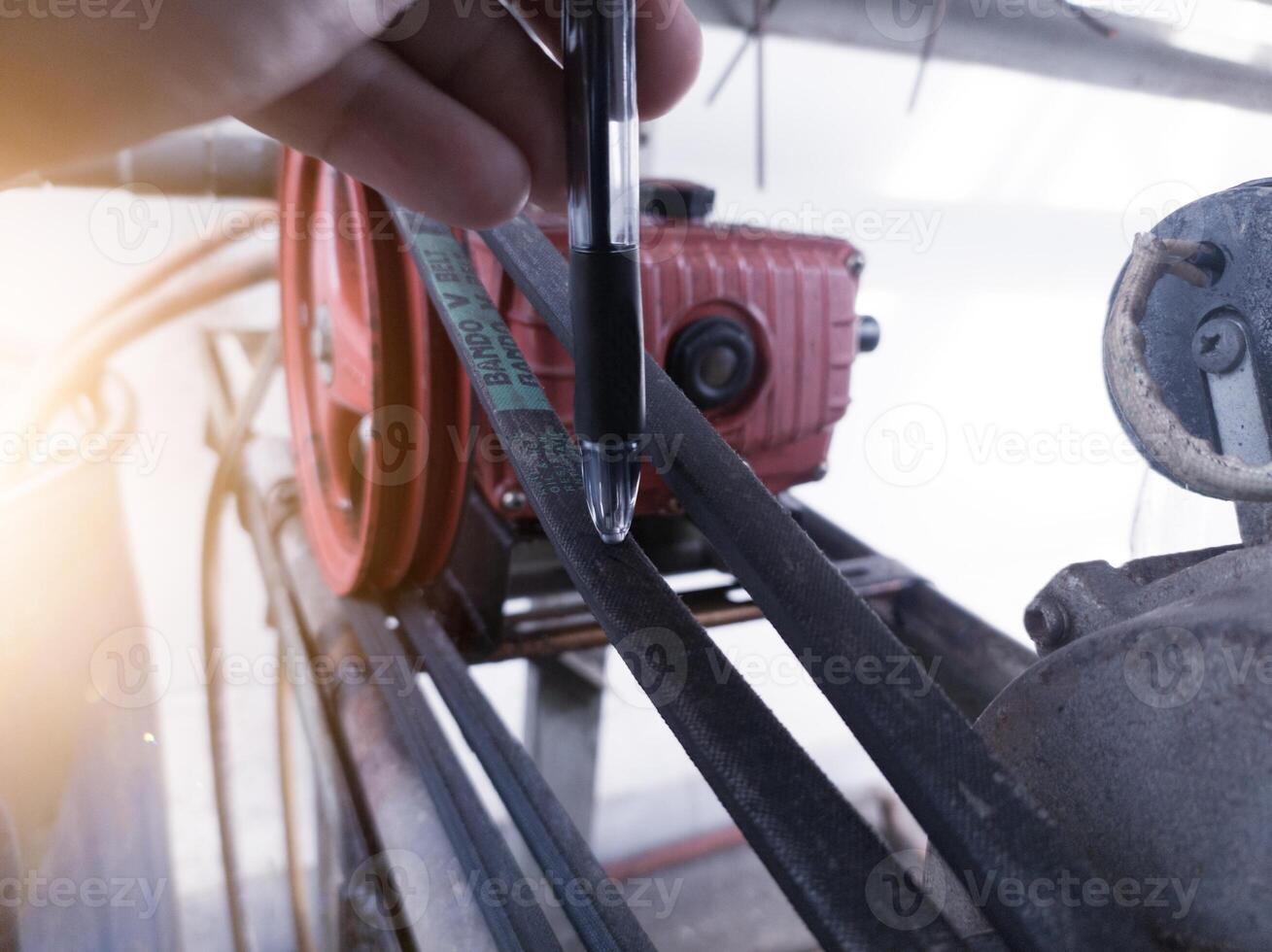 Checking the tenssion of the belt pulley using hand estimates. photo