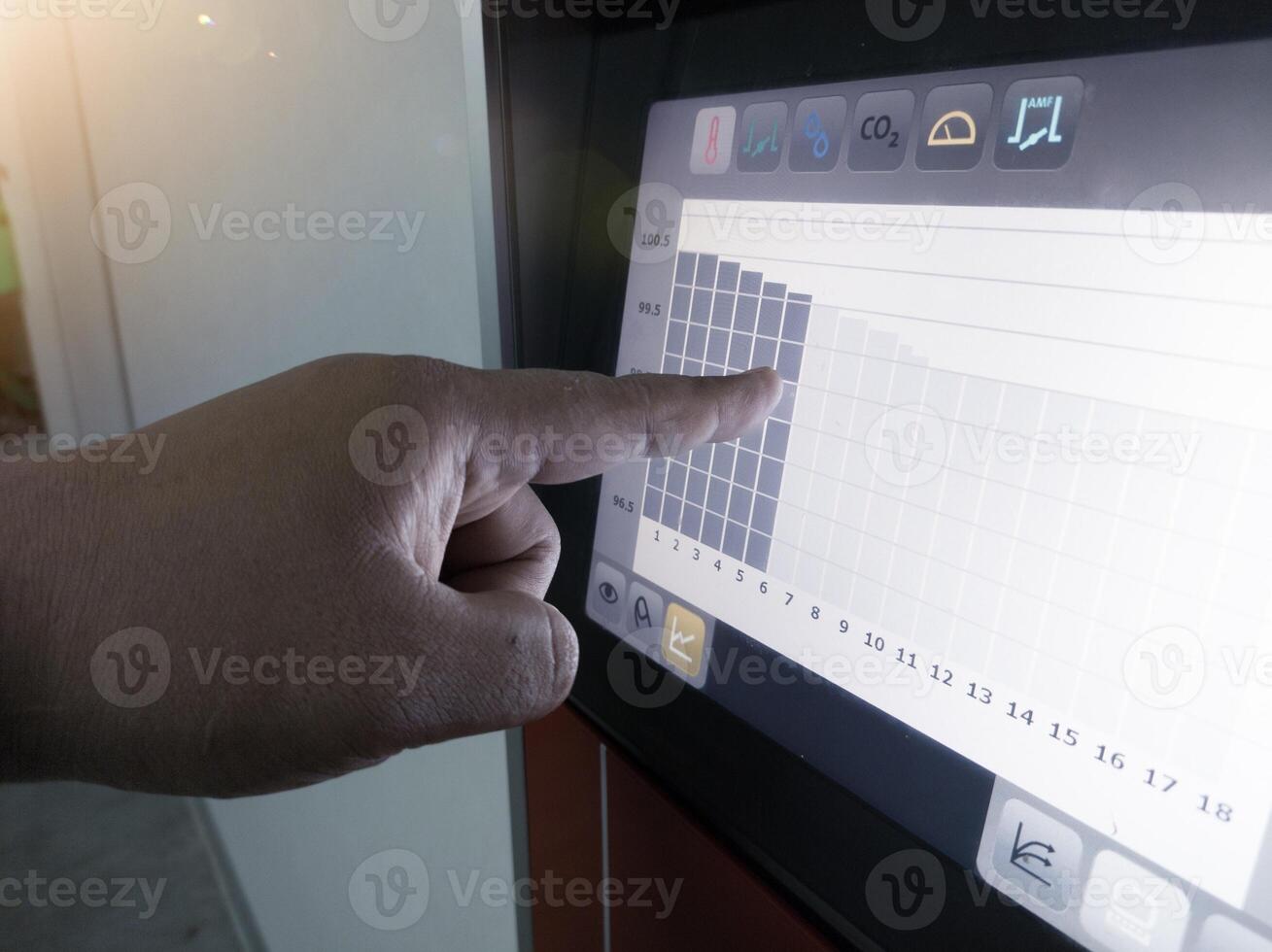 The engineer an engineer is pointing at a display data graphics on display Technology of  hatchery machine. photo