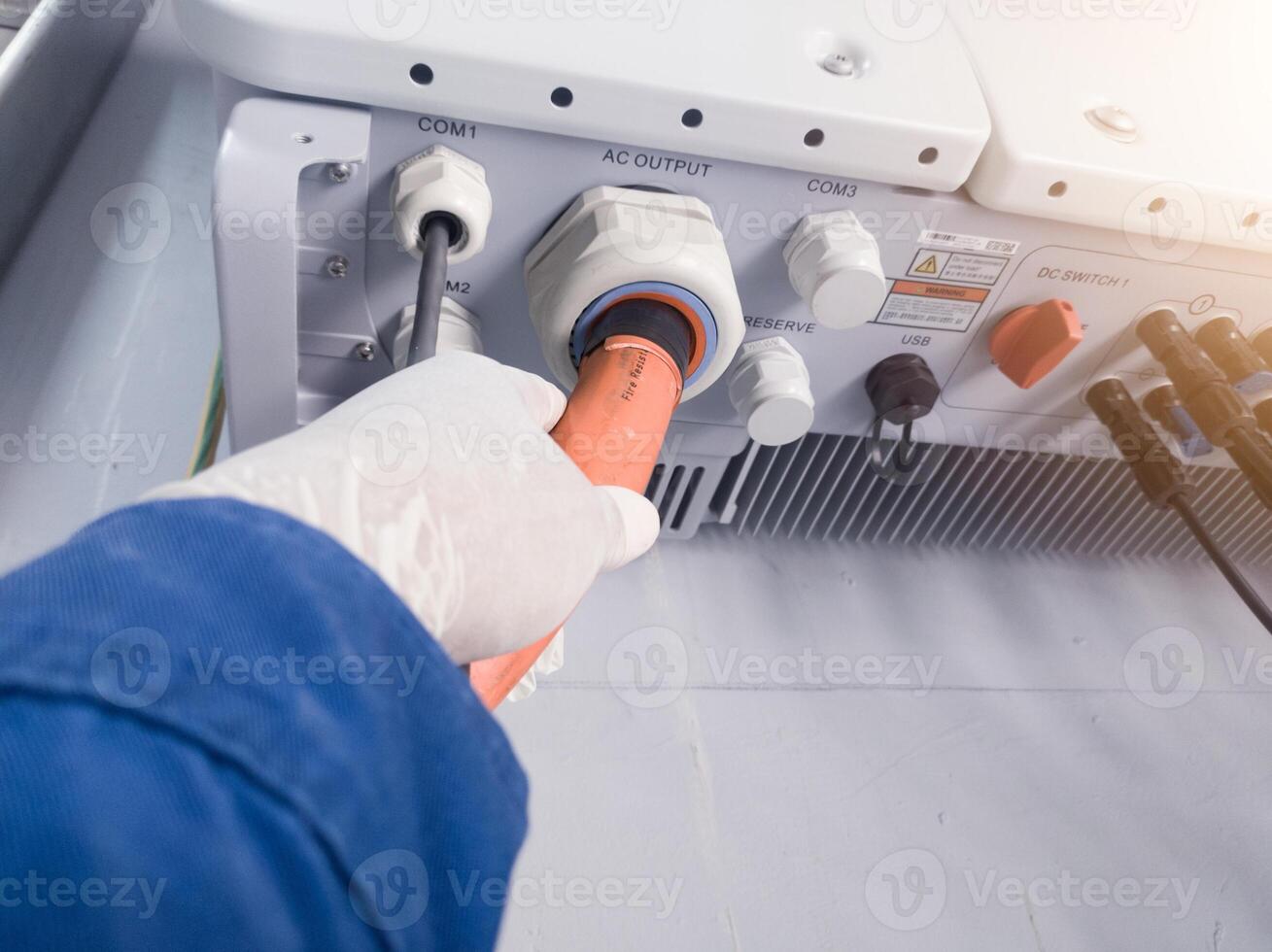 A engineering checking power cable lines in inverter solar panel. Electrical service concept. photo