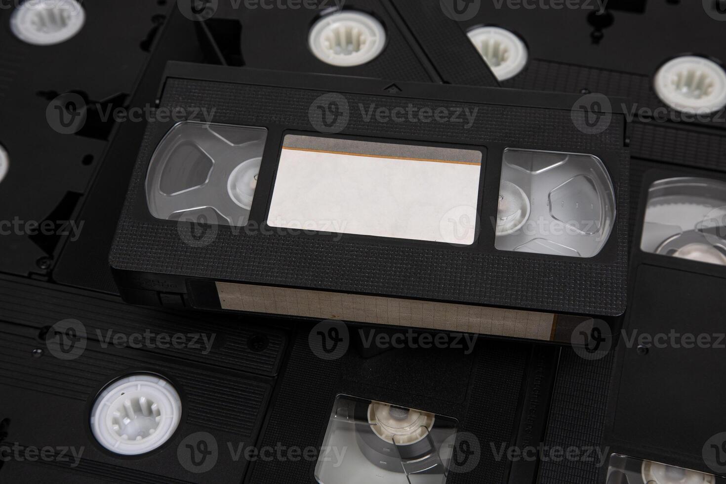 filmar con una videocámara con blanco etiquetas pila de vhs vídeo casetes Clásico medios de comunicación. aislar en un blanco espalda foto