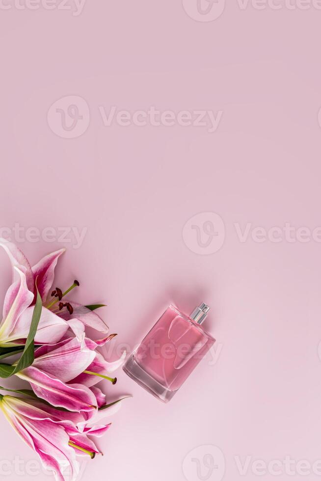 Elegant bottle of cosmetic spray or women's perfume on pastel vertical background with delicate lilies. A copy space. Blank layout for product. photo