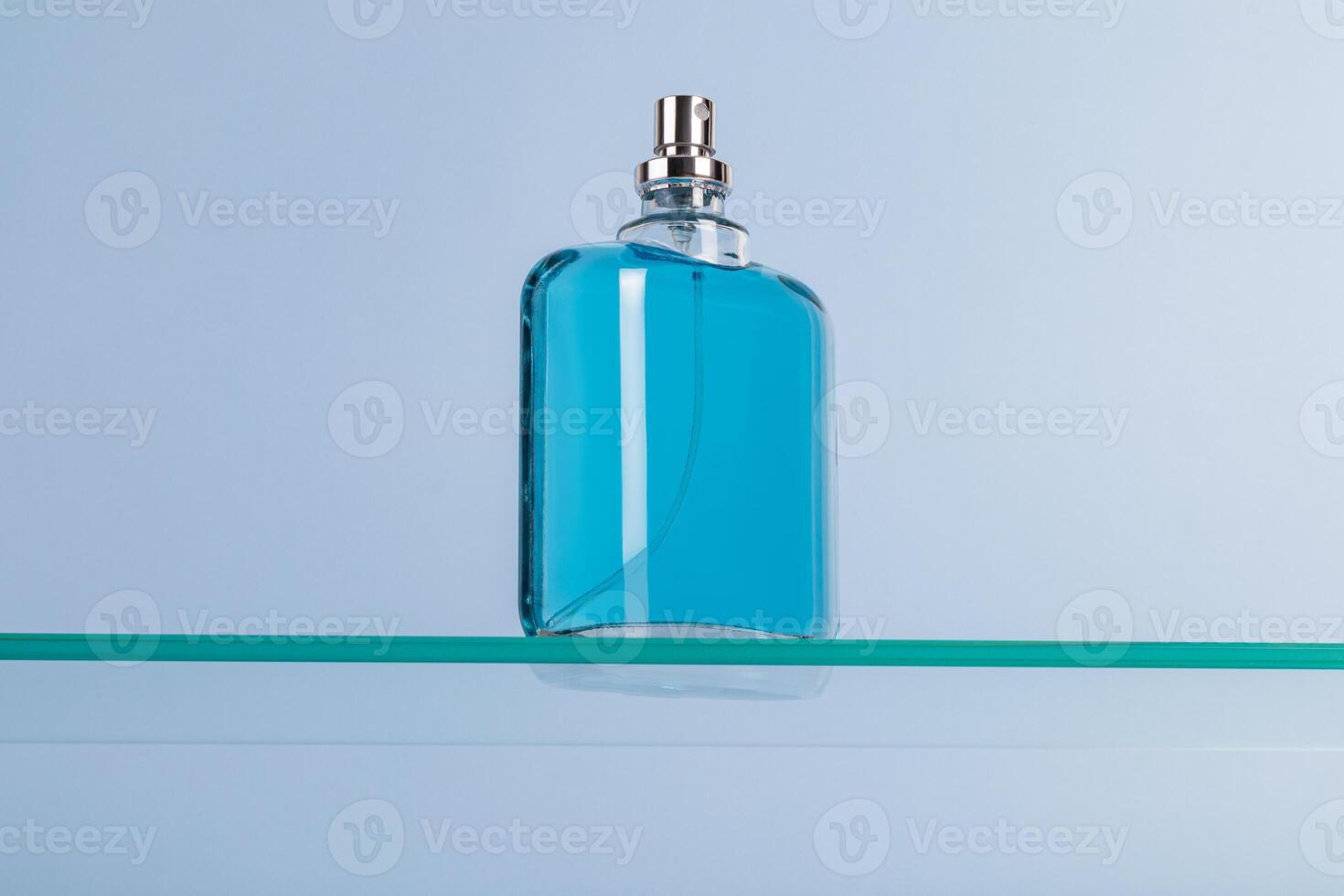 hermosa vaso botella de cosmético rociar, perfume, eau Delaware baño en un flotante vaso superficie. azul antecedentes. producto presentación. modelo. foto