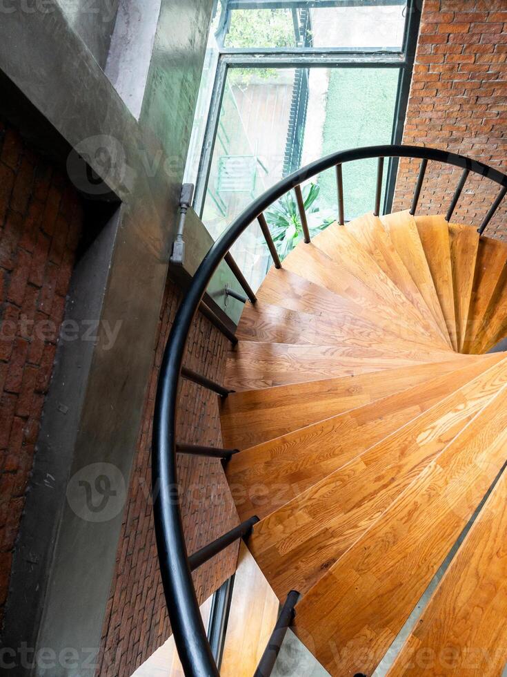 Wooden spiral staircase with the metal railing. photo