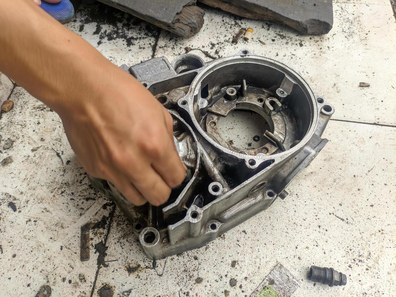 close up of hands cleaning a motorbike engine photo