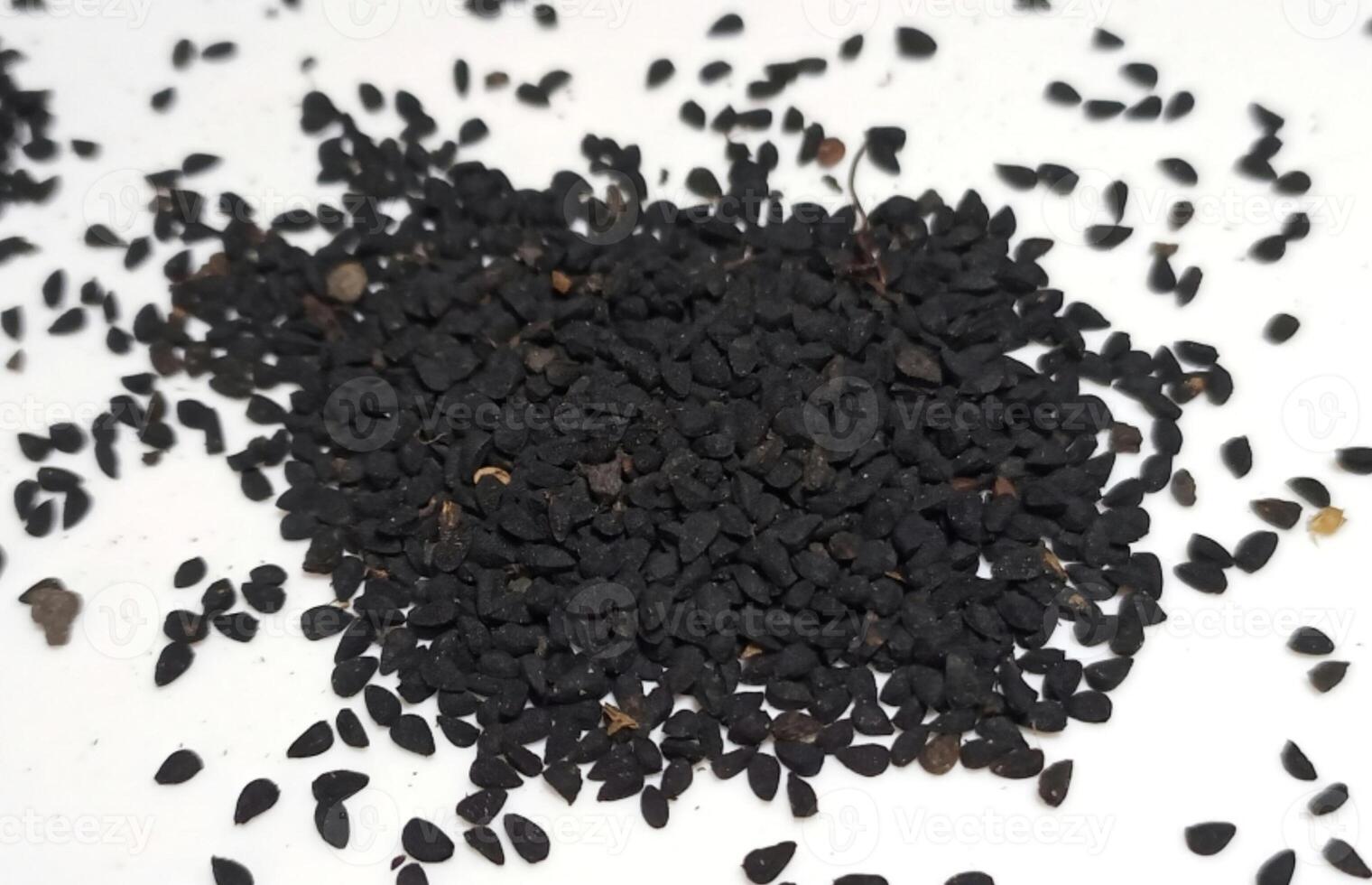 Black cumin seeds pile isolated on white background photo