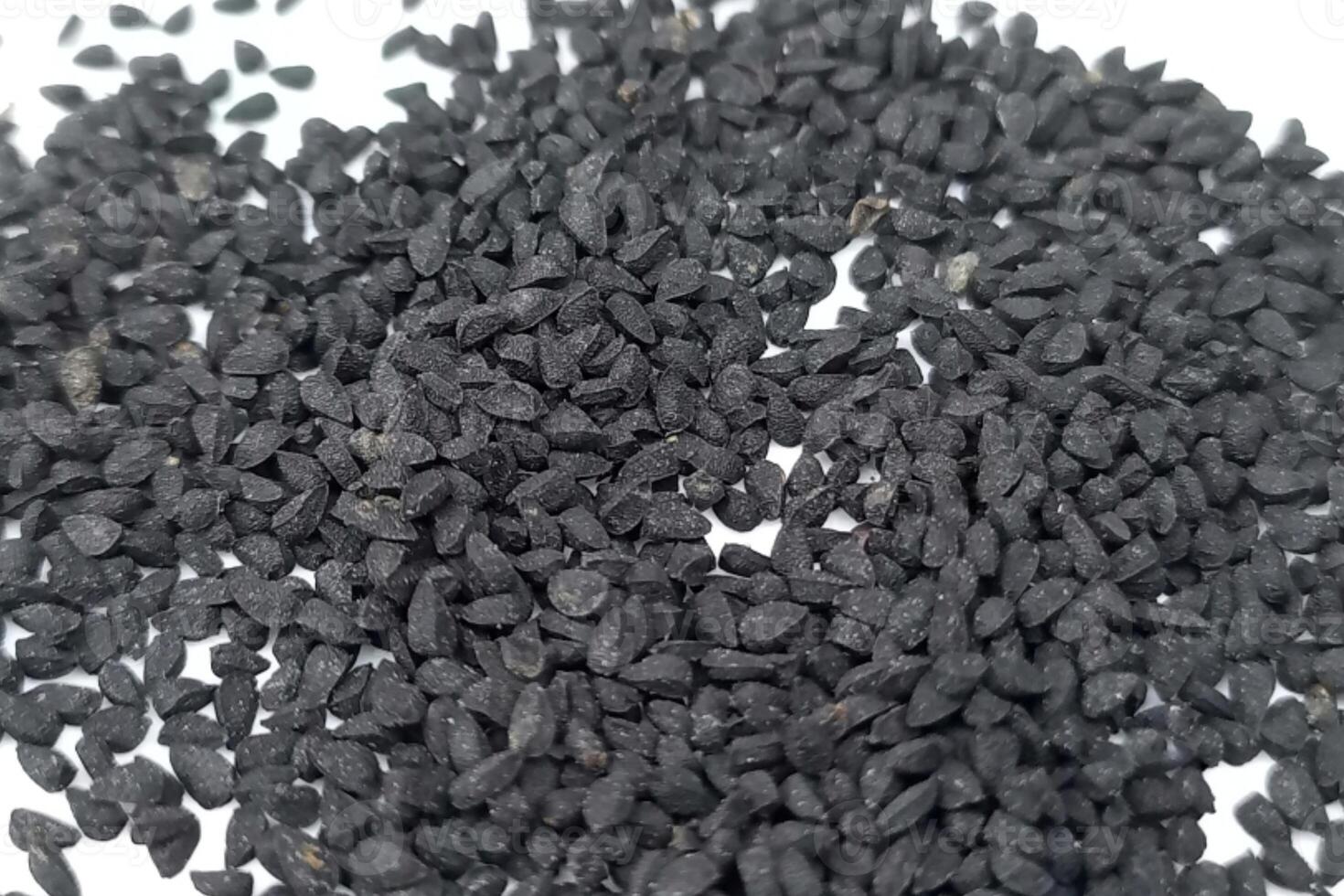 Black cumin seeds pile isolated on white background photo
