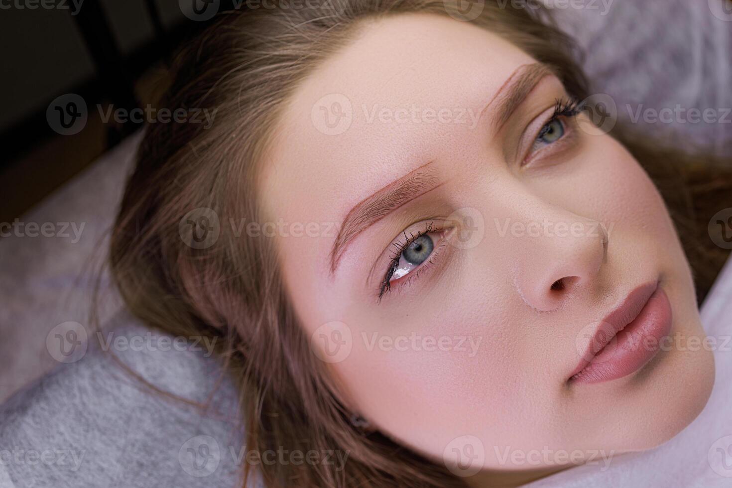 Cute girl model with markings on her eyebrows before permanent makeup procedure. PMU Procedure, Permanent Eyebrow Makeup. photo