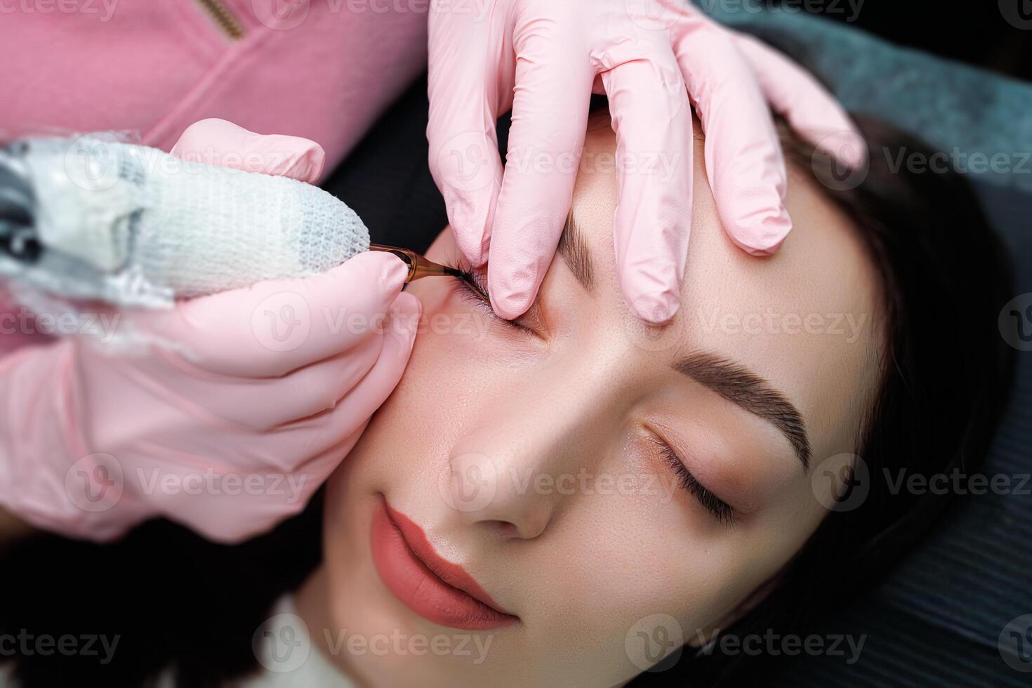 Girl model at the procedure of permanent makeup of eyelashes. Permanent eye makeup and PMU eyelashes photo