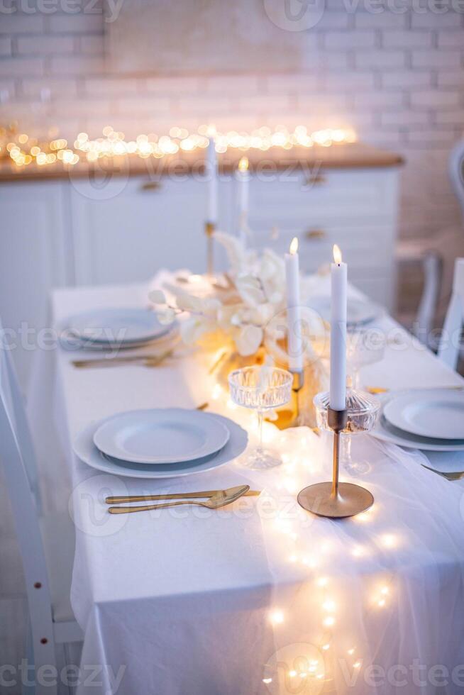 Festive table setting with candles, plates and cutlery. photo