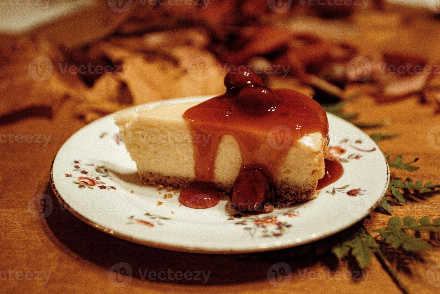 Cheesecake with caramel sauce and cherries on a wooden table photo