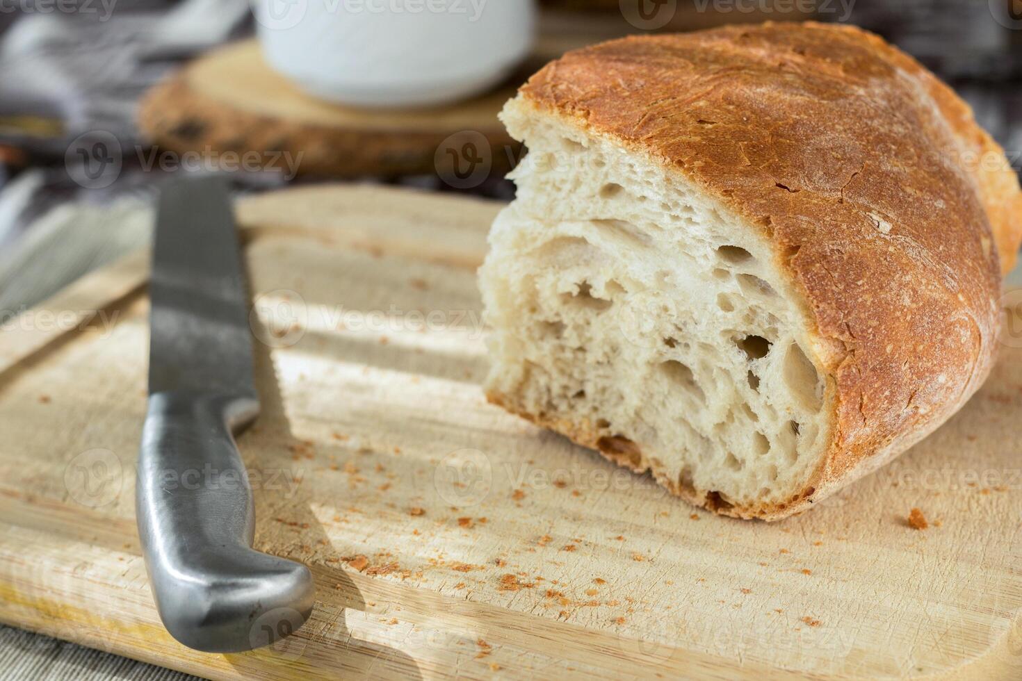 ciabatta un pan en un corte tablero con un cuchillo. foto