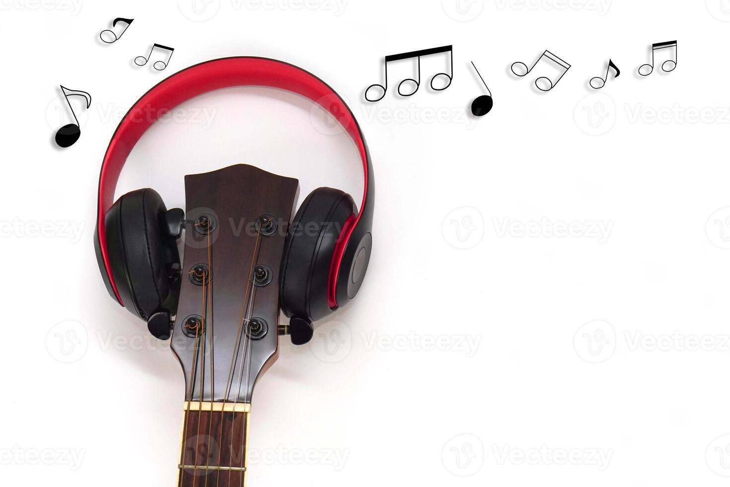 Acoustic guitar, headphones and music notes on a white background. Love and music concept. photo