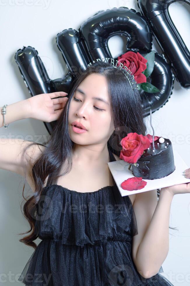 A woman holding a cake and a rose photo