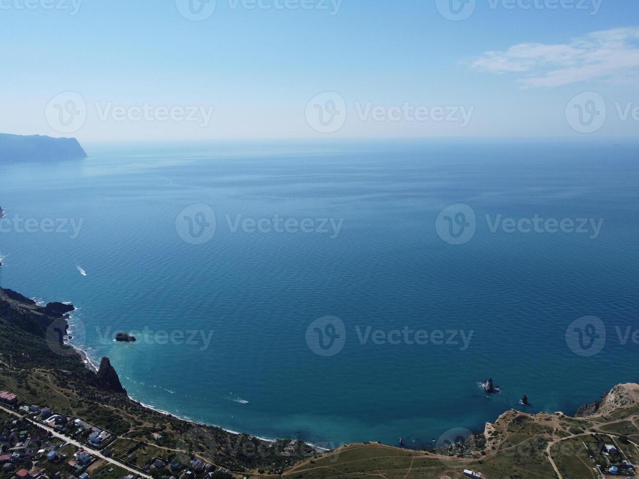 Aerial view from above on calm azure sea and volcanic rocky shores. Small waves on water surface in motion blur. Nature summer ocean sea beach background. Nobody. Holiday, vacation and travel concept photo