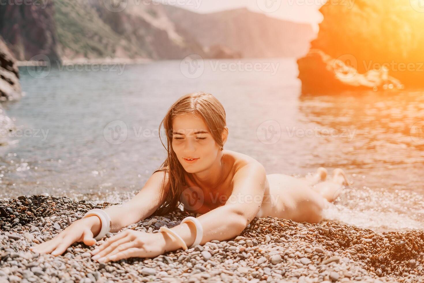 Woman travel sea. Happy tourist in hat enjoy taking picture outdoors for memories. Woman traveler posing on the beach at sea surrounded by volcanic mountains, sharing travel adventure journey photo