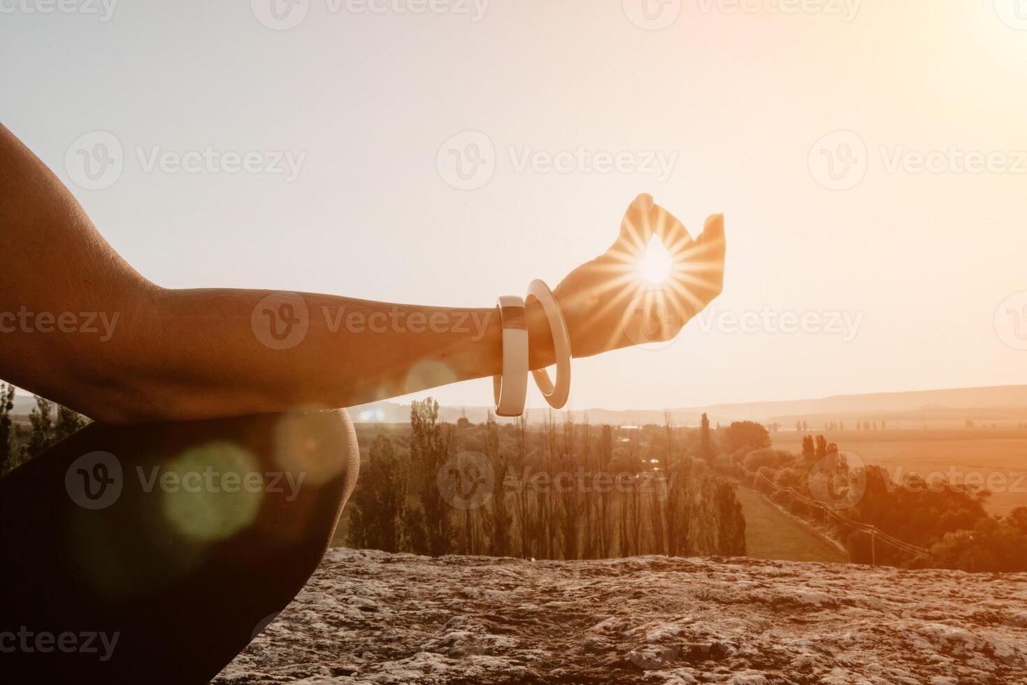 Fitness woman. Happy middle-aged fitness woman doing stretching and pilates on a rock near forest at sunset. Female fitness yoga routine. Healthy lifestyle with focus on well-being and relaxation. photo