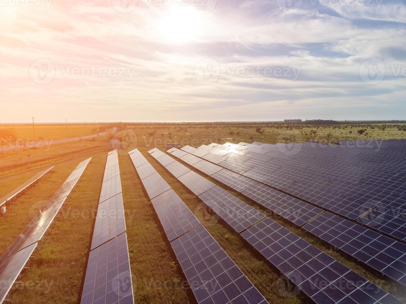 Aerial top view of a solar panels power plant. Photovoltaic solar panels at sunrise and sunset in countryside from above. Modern technology, climate care, earth saving, renewable energy concept. photo