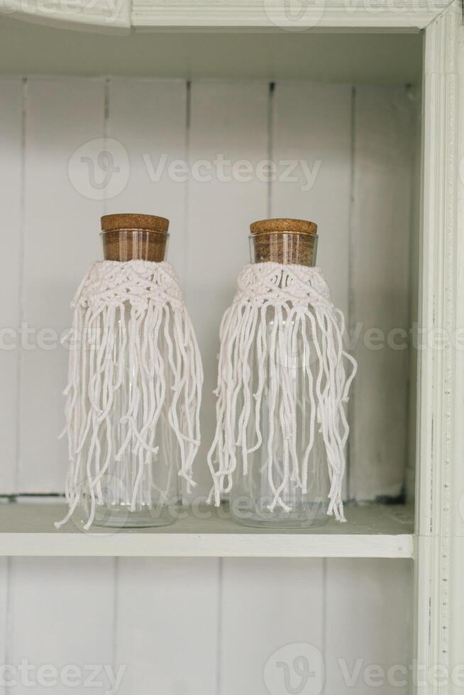 Glass bottles with white strings hanging from them photo