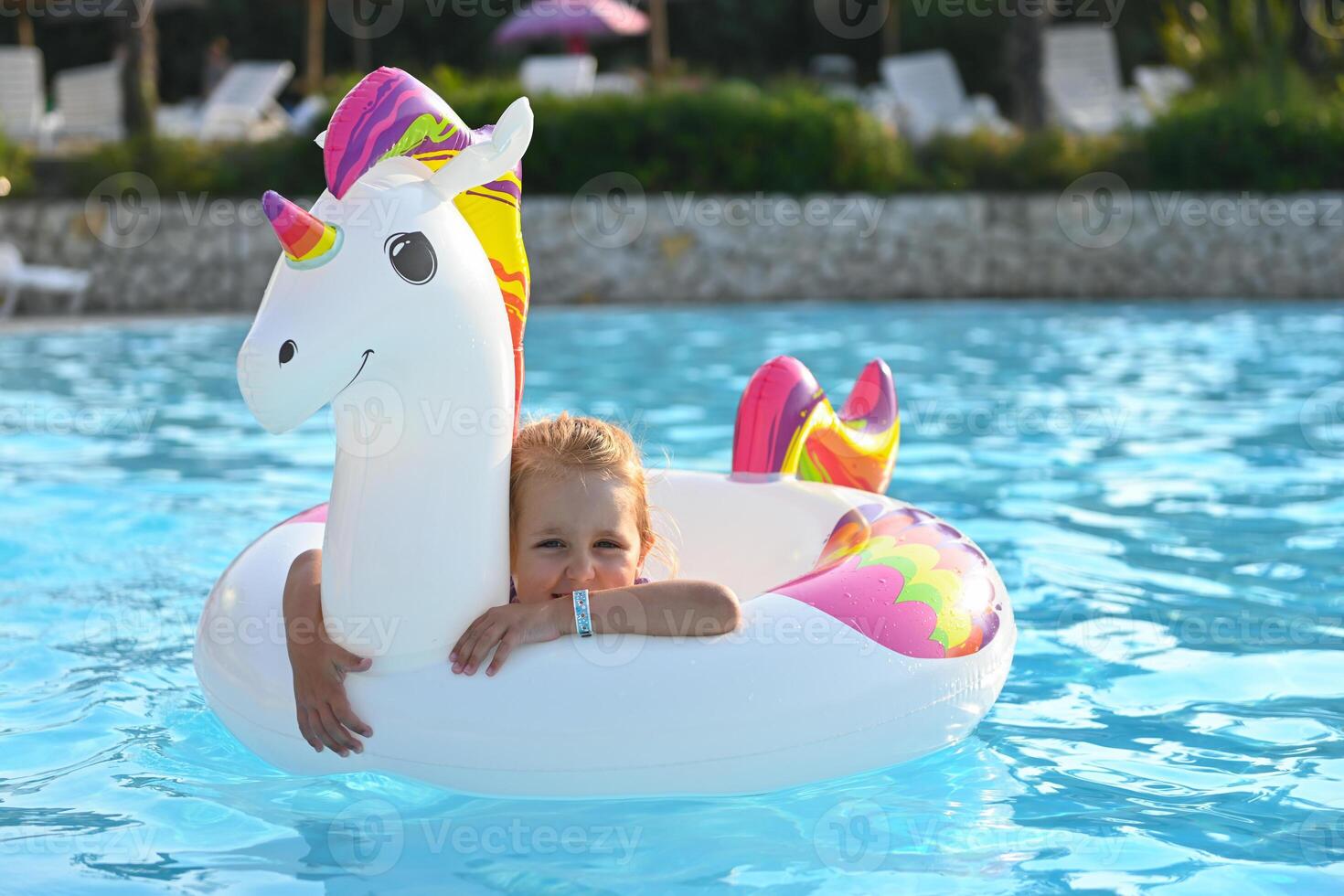 Small cute girl in swimming pool with inflatable toy photo
