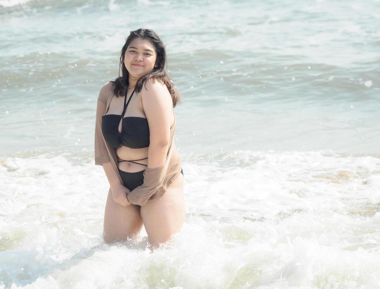 Portrait young asian woman fat chubby cute beautiful smile happy fun enjoy relax bikini swimwear body sexy front view sea beach white sand clean bluesky calm nature ocean wave water travel on holiday photo