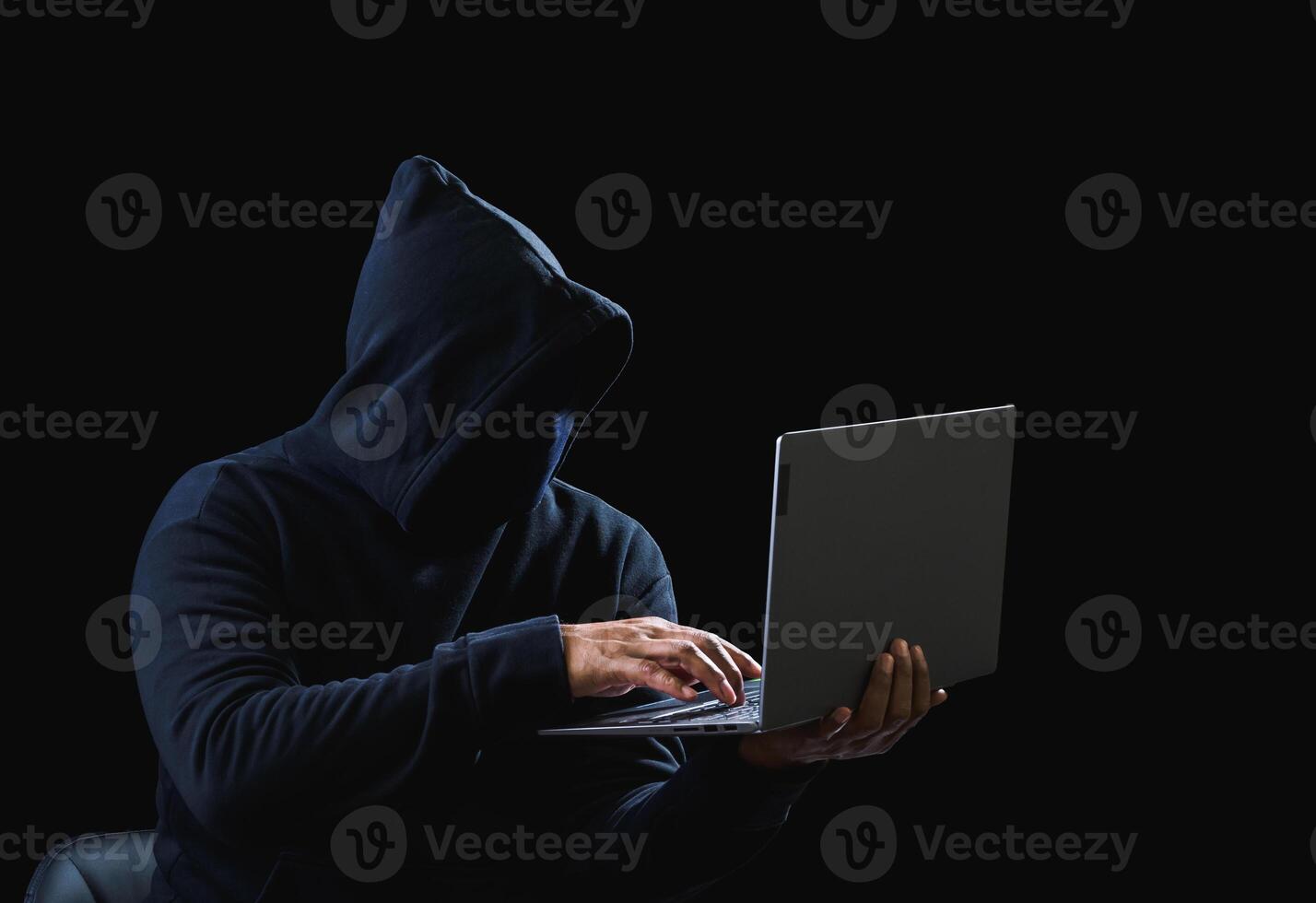 Portrait hacker spy man one person in black hoodie sitting on table looking computer laptop used login password attack security to data digital internet network system night dark background copy space photo