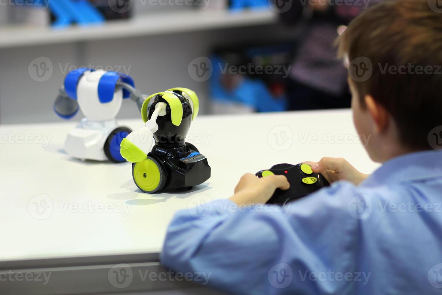 Boy playing battle fighting robots with remote control. Robotics, STEM photo