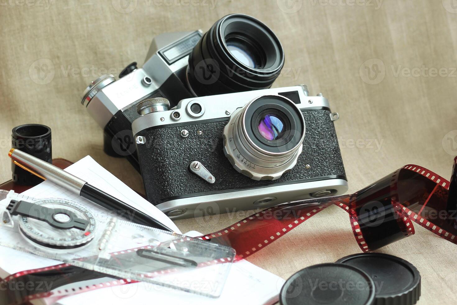 Classic still life with retro cameras, films, notebooks, compass and pen on canvas photo