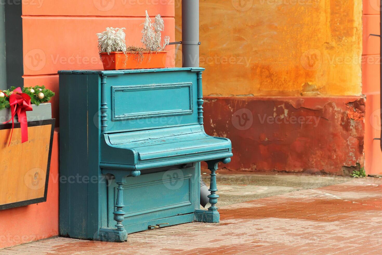 Vintage weathered aquamarine piano outdoor in the street downtown photo