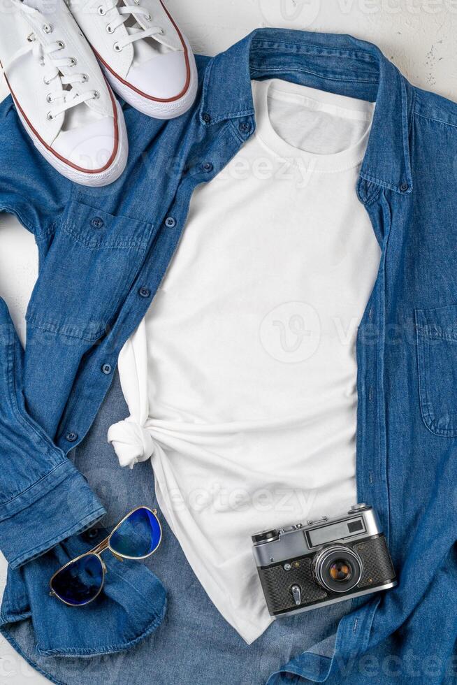 White T-shirt with place for text. Blue denim shirt, sneakers, glasses - a set of clothes for walking. T-shirt mockup for printing. Stylish kit photo