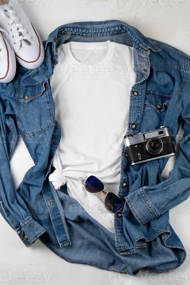 White T-shirt with place for text. Blue denim shirt, sneakers, glasses - a set of clothes for walking. T-shirt mockup for printing. Stylish kit photo