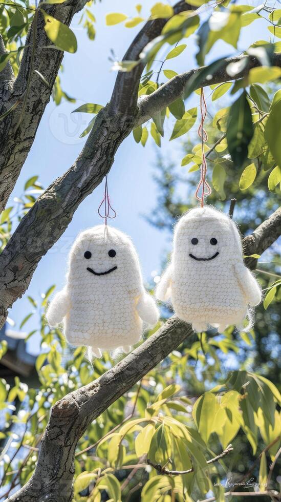 AI generated Two cute white smiling ghost dolls cotton hanging on a tree, green leaves background. photo