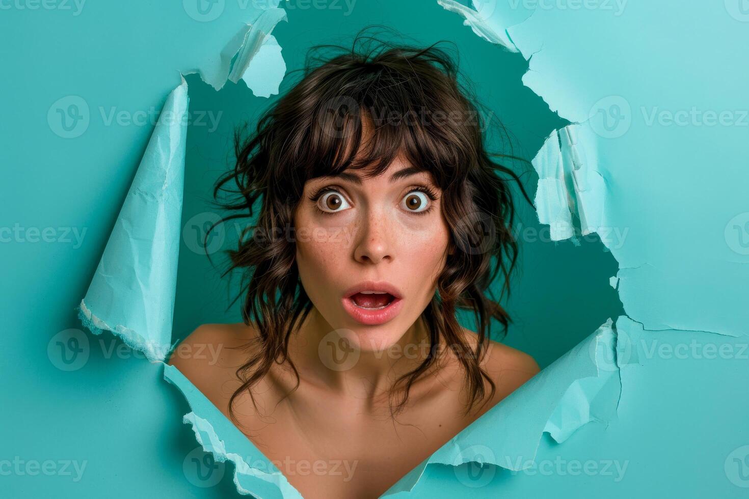 AI generated A woman's face expresses shock and curiosity as she peers through a torn teal paper, capturing a moment of surprise and intense emotion photo