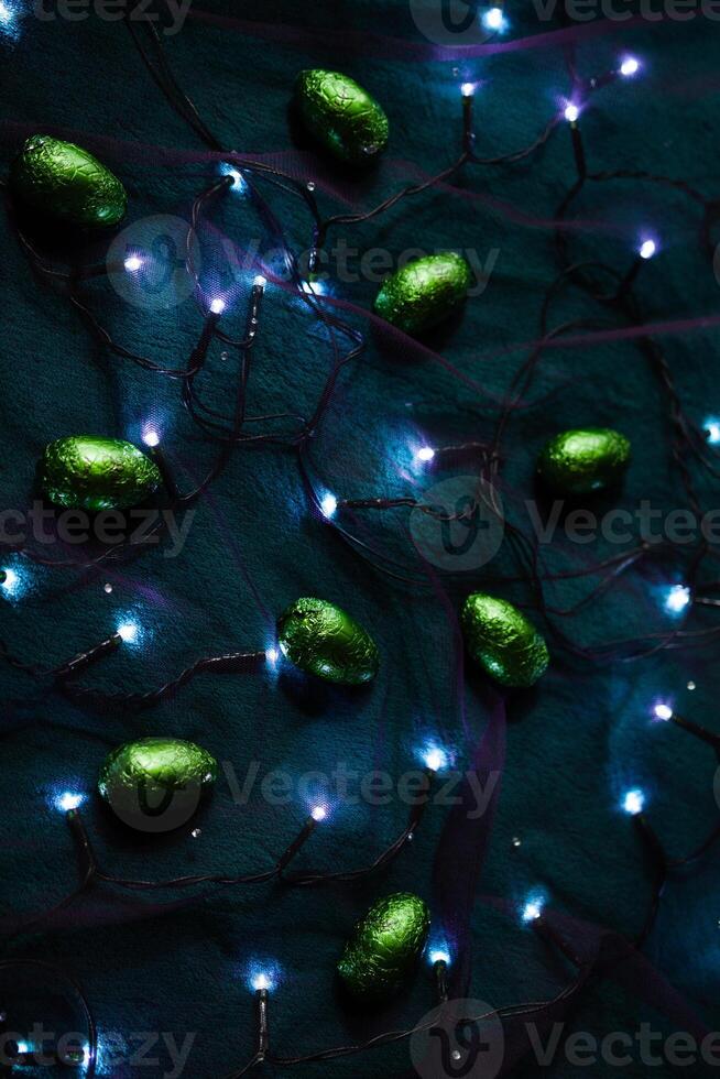 Sparkling green eggs among the lights of garland photo