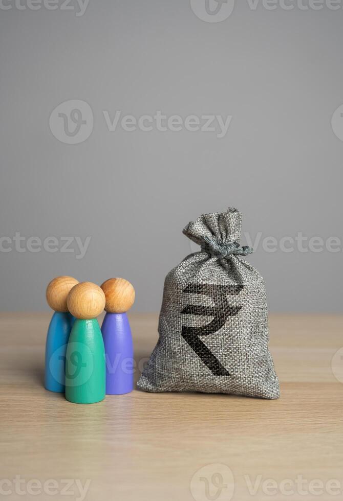 personas estatuillas y indio rupia dinero bolsa. financiero apoyo. compensación pagos Proporcionar dinero, pago sueldos y subsidios. social asistencia. foto