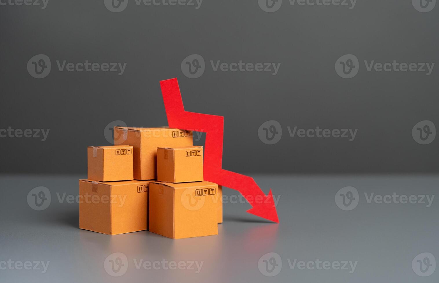 Boxes with goods and down arrow. Falling prices. Reduction in supplies and production rates. Deterioration in the attractiveness of goods, low demand. Economic GDP slowdown. Tax reduction. photo