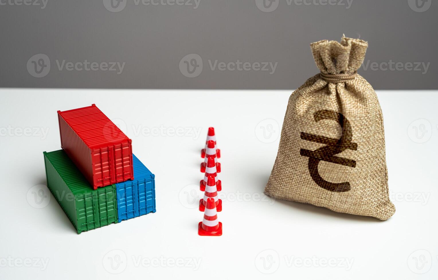 Shipping containers with goods and ukrainian hryvnia money bag are separated by a barrier. Difficulties in trade. Break a trade deal. Naval blockade. Logistics difficulties. Economic sanctions. photo