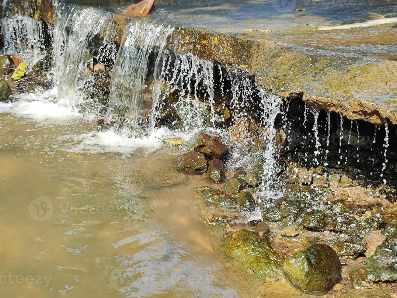 Water flows from top to bottom through the cave inside photo