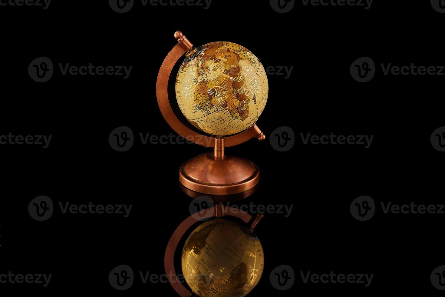 Globe rests on dark surface, surrounded by auto lighting, glass and metal items photo