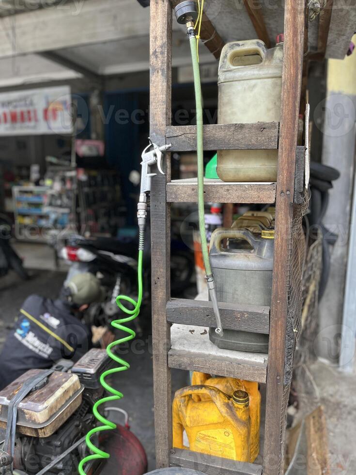 Car repair shop, air pump machine compressor, pile of used oil bottles and used tires photo