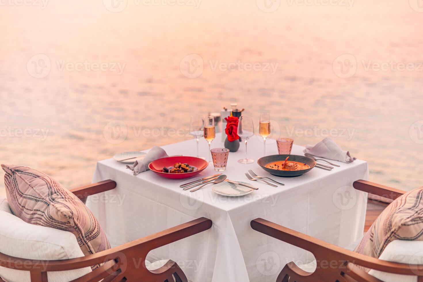 marina ver debajo puesta de sol ligero con comida mesa con infinito piscina alrededor. romántico tranquilo Aléjate para dos, Pareja concepto. sillas, comida y romance. lujo destino comida, Luna de miel modelo foto