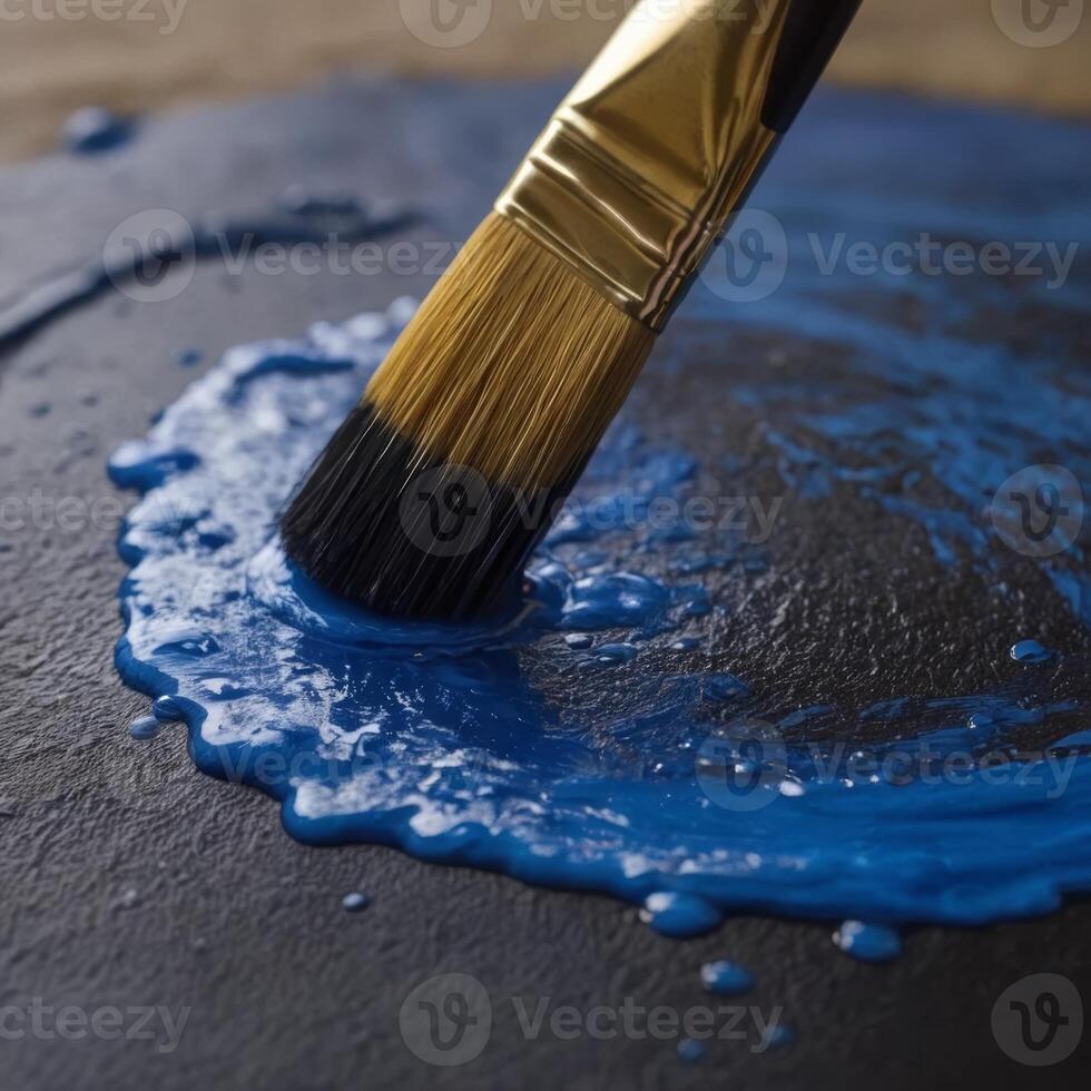 The image captures a close-up view of a paintbrush with golden hardware, applying vibrant blue paint onto a surface. The texture and glossiness of the wet paint are prominently displayed photo